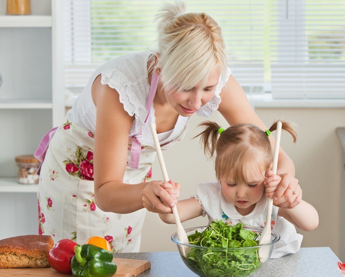 ></p>
<p> </p>
<p>Вы любите готовить? Даже если вы ответили на вопрос отрицательно, приготовление пищи вместе с ребенком в корне изменит отношение к этому процессу. Дети – великие выдумщики, которые помогут превратить готовку в веселое, увлекательное и полезное занятие.</p>
<p> </p>
<p>Итак, готовим с ребенком. </p>
<p> </p>
<p><strong>С какого возраста можно привлекать ребенка к участию в приготовлении пищи?</strong></p>
<p> </p>
<p>Готовить вместе с ребенком мы можем начать буквально с пеленок. Ведь с самого рождения большую часть времени малыш проводит с мамой. Уже с шести-восьми месяцев, когда ребенок начинает самостоятельно сидеть, можно на  некоторое время оставлять его в стульчике для кормления (или в шезлонге) просто понаблюдать за тем, что вы делаете. За вашими действиями без сомнения будут следить любопытные глазки. Любое ваше действие, будь то чистка картошки или нарезка помидоров, привлечет внимание младенца. Помните, что все должно быть максимально естественно, не стоит ставить сценки из жизни овощей.</p>
<p> </p>
<p>Уже в год ребенку можно купить набор из деревянных или пластиковых овощей, которые разрезаны надвое и соединены между собой липучкой. Также существует огромное количество игрушечной кухонной утвари: столовые приборы, разделочные доски, наборы для чаепития. Вариантов масса. Каждый раз, когда готовите сами, давайте ребенку игрушечные овощи/фрукты, пусть «помогает». Подобного рода игры помогают ребенку быстро научиться различать продукты, логически размышлять, подыскивая нужные половинки, развить мелкую моторику.</p>
<p> </p>
<p>В полтора года малышам еще слишком рано готовить блюдо от начала до конца, однако, это прекрасный возраст для первых гастрономических экспериментов. В это время детки активно учатся использовать мышцы рук и смогут помочь достать мякиш из хлеба; помыть овощи в мисочке; смешать в глубокой тарелке сухие ингредиенты; размять ложкой ягоды для приготовления пюре, соуса, смузи; оборвать листочки у петрушки; полущить горошек или «раздеть» кукурузу. Крохе можно доверить «финальный штрих» в приготовлении блюда – украшательство. Например, посыпать рубленой зеленью салат, семечками – тыквенный суп, сахарной пудрой – румяный коржик. Домашняя стряпня отлично стимулирует развитие у детей мелкой моторики и концентрацию внимания. Например, пусть малыш набирает в пипетку жидкость, а затем переливает ее в формочки для льда. Или пересыпает крупы из одной емкости в другую. Удачный момент для того, чтобы купить малышу первый фартук.</p>
<p> </p>
<p>С трех лет под присмотром взрослых дети могут научиться разбивать яйцо в миску и взбивать его в пену. Также можно замесить и раскатать тесто, а затем с помощью специальных приспособлений вырезать различные фигурки. Можно попробовать разрезать безопасным пластиковым ножом мягкие продукты: вареное яйцо или банан; сбрызнуть салат маслом или лимонным соком и тщательно его перемешать; натереть сыр; намазать сливочное масло на хлеб; замерить жидкости и сыпучие продукты в соответствии с рецептом.</p>
<p> </p>
<p>У детей в возрасте до 6 лет внимание по-прежнему рассеянное. Поручайте им быструю, простую работу и давайте пошаговые указания. После приготовления блюда можно поиграть с детьми в «ресторан»: торжественно накрыть на стол, правильно разложить приборы, красиво свернуть салфетки.</p>
<p> </p>
<p><strong>О чем не стоит забывать во время кулинарных этюдов</strong></p>
<p> </p>
<p>Первое, о чем стоит помнить – безопасность. Следите за тем, что попадает в руки вашего малыша, и, разумеется, исключите возможность контакта с колюще-режущими предметами.</p>
<p> </p>
<p>Второе – специальное место для ребенка. Если размер кухни позволяет, то желательно выделить ребенку для готовки отдельный уголок.</p>
<p> </p>
<p>Третье – кулинарная гигиена, научить малыша которой можно с ранних лет. Ведь «общаясь» с продуктами мы даем простор для деятельности микробов и бактерий. Необходимо демонстративно мыть вместе с ребенком руки и хорошенько протирать все кухонные поверхности.</p>
<p> </p>
<p><strong>Чем полезны совместные занятия кулинарией</strong></p>
<p> </p>
<p>На кухне дети учатся и развиваются через прикосновения, дегустацию, ароматы. </p>
<p> </p>
<p>Помогая на кухне, ребенок, сам того не замечая, познакомится с понятиями «вес», «размер», «часть», узнает единицы измерения, научится складывать, считать и выполнять простые арифметические действия. </p>
<p> </p>
<p>Строя башни из тарелок и стаканов (запаситесь детской пластиковой посудой) ваше чадо развивает фантазию и творчество.</p>
<p> </p>
<p><em>Совместная деятельность помогает развить чувство защищенности.</em></p>
<p> </p>
<p>Помощь на кухне очень важна для ребенка, так как он начинает чувствовать свою нужность и значимость, приобретает множество навыков, учится самостоятельности и ответственности.</p>
<p> </p>
<p>Совместная готовка разжигает аппетит ребенка, ведь приготовленное самостоятельно блюдо выглядит гораздо вкуснее того, что куплено в магазине.</p>
<p> </p>
<p>Приготовление пищи – один из наглядных способов показать ребенку пользу от умения читать. </p>
<p> </p>
<p>Умение готовить дает ребенку представление о том, откуда берется еда.</p>
<p> </p>
<p>Так что готовить вместе не только вкусно, но и полезно. Можно также завести кулинарную книгу, куда вы будете записывать любимые рецепты, а ребенок пусть дополняет их иллюстрациями.</p>
<p> </p>
<p style=