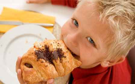 Ребенок кушает круассан